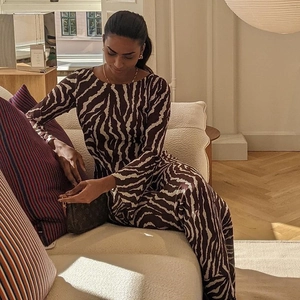 Detail of bohemian zebra print dress fabric and pattern on a woman sitting on a sofa