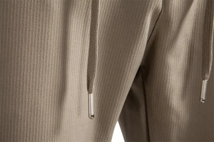 Macro shot of khaki ribbed fabric texture and premium silver metal drawstring tips