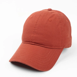 Detail view of cotton baseball cap showing brick red fabric texture and 6-panel stitching