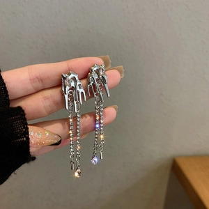 Vue détaillée de boucles d'oreilles en métal liquide avec zircon rose et longs glands
