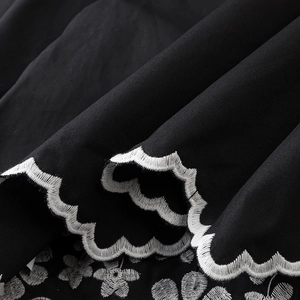 Elegant black shirt with white floral embroidery and scalloped lace trim details