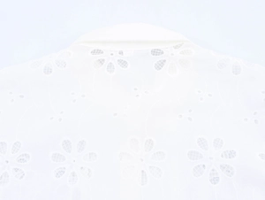 Detail of white blouse featuring intricate floral water-soluble lace and back collar design