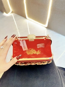 Detail view of open red glitter evening clutch with gold chain and satin lining