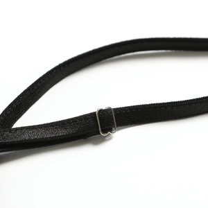 Macro detail of high-quality black elastic strap and silver metal buckle on a dress