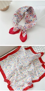 Detail of square cotton linen scarf featuring colorful star patterns and red borders
