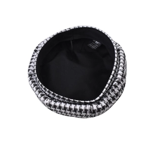 Detail of houndstooth beret showing black and white texture and 100% polyester label