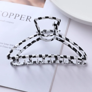 Macro shot of checkered black and white triangular hair claw clip with metal spring detail