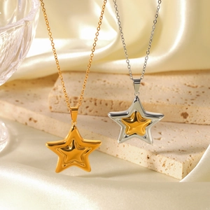 Macro detail of gold and silver mixed tone star pendant necklaces on stone background