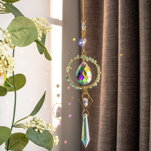 Golden suncatcher with peridot stones and crystal prisms casting rainbows on windows