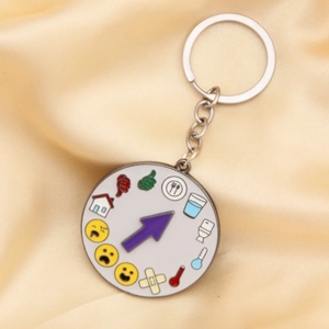 Close-up of rotatable mood social battery keychain with 12 emoji icons on silk background