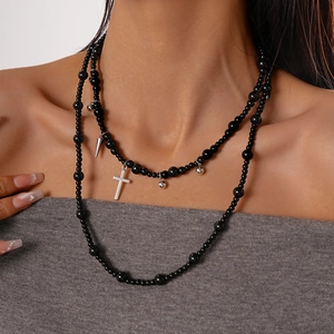 Close-up of double-layered gothic black bead necklace with silver cross and spike charms