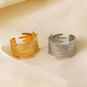Adjustable stainless steel feather rings in 18K gold and silver finishes on silk fabric