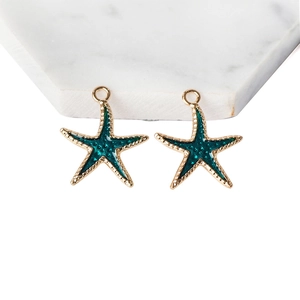 Golden starfish alloy pendants with dark green enamel on white marble base