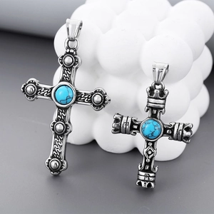 Macro detail of retro steel cross pendants with turquoise stones and vintage relief