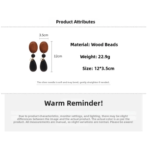 Detail view of long drop earrings with brown wood beads and black teardrop pendant