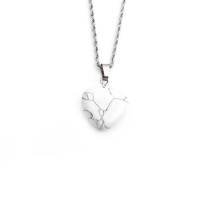 Detail showing a heart-shaped white turquoise pendant with black marble patterns on a rope chain
