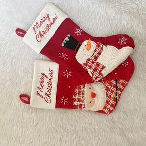 Detail of red Christmas stockings with plush Snowman and Santa Claus embroidery