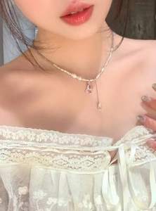 Primo piano di un'elegante collana di perline argentate con ciondolo a farfalla lavanda