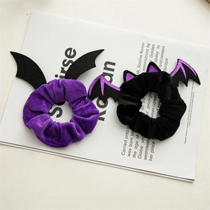 Detail of Halloween bat wing velvet hair scrunchies in purple and black glitter