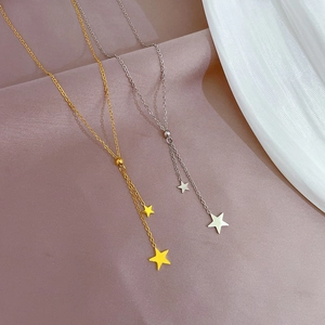 Detailed close-up of gold and silver Y-shaped necklaces with star pendants on soft fabric