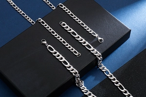Vue détaillée de la chaîne Figaro argentée et du bracelet avec une finition en métal poli