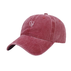 Casquette vintage en coton rouge délavé avec broderie de cœur vue sous un angle de 45°