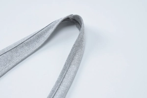 Dettaglio del tessuto a maglia grigio e delle cuciture precise della tuta intera halter