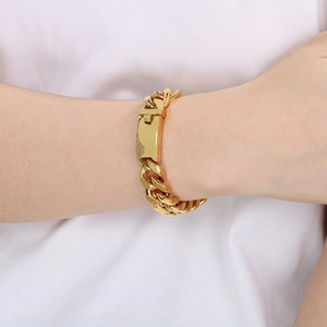 Detail of 13mm 18K gold plated Cuban chain bracelet worn on wrist showing polished link texture