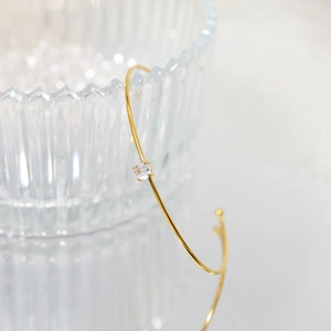 Minimalist 18k gold plated stainless steel open bangle with a moissanite stone accent
