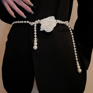 Detail der eleganten zweireihigen Perlen-Taillenkette mit weißen Blumen auf schwarzem Blazer