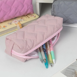 Detail view of pink quilted stationery bag with diamond pattern and zipper closure