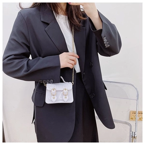 Detail of light purple jelly handbag with gold chain and magnetic buckle on model