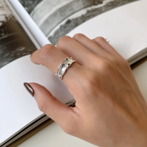 Detailed view of irregular S925 silver ring with hammered texture and green stones