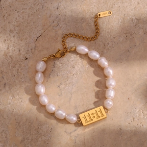 Detailed close-up of freshwater pearl bracelet with 11:11 engraved gold rectangle plate