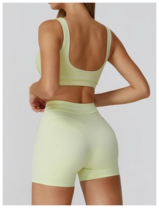 Detail view of contrast stitching and U-shaped back on yellow sports bra and shorts
