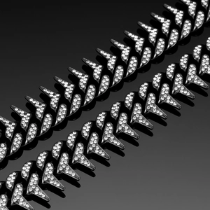 Detailed close-up of 20mm black iced out Cuban link chains with spikes and crystals