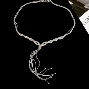 Detail of silver multi-layer fringe necklace with polished tassels on black velvet