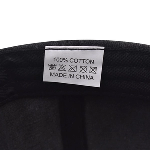 Close-up of internal wash label on 100% cotton baseball cap showing care instructions