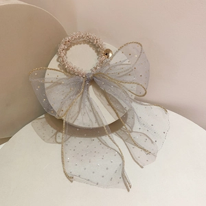 Close-up of grey mesh bow hair scrunchie with glitter and crystal beads on a stand