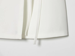 Detailed view of the white cotton-linen skirt hem and elegant waist tie-up strings