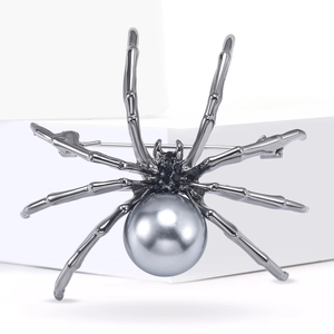 Detailed view of silver spider brooch with grey pearl and black rhinestone accents