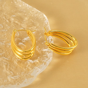 Polished 18k gold-plated triple layer hoop earrings set on aesthetic glass display