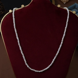 French irregular natural freshwater pearl necklace on a red velvet display stand