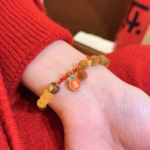 Nahaufnahme eines Vintage-Armbandes aus roten Achatperlen mit Phönix-Anhänger am Handgelenk