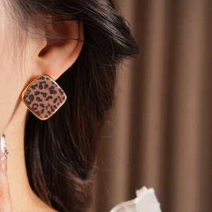 Gros plan de boucles d'oreilles carrées léopard avec bord doré sur un modèle