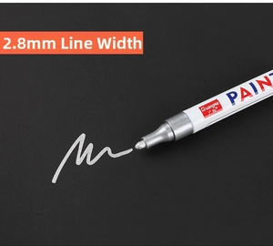 Close-up of a silver paint marker with a 2.8mm nib on a black background