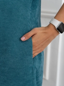 Close-up of side pockets on teal corduroy midi dress with fine ribbed texture details