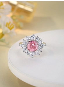Macro detail of silver ring featuring a pink square gemstone with floral diamond halo