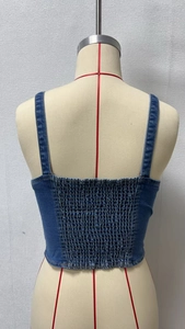 Detail view of the stretchy smocked back on this dark blue denim vest for women