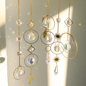 Golden suncatcher crystal balls with metal geometric frames hanging in natural sunlight